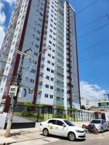 a white car parked in front of a tall building at Apê moderno no Centro, perto de tudo em Belém in Belém