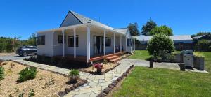 a small white house with a yard at Bumble Bee Cottage in Kerikeri