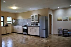 a kitchen with a stainless steel refrigerator in a room at Uitvlugt Ponds in Dullstroom