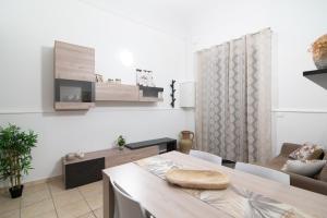 a living room with a dining table and a tv at Dimora Saracena in Adrano