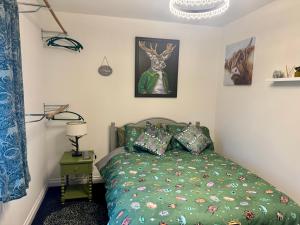 a bedroom with a bed with a green comforter at Willow Cottage in North Muskham