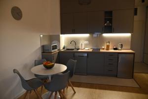 a kitchen with a table and chairs and a kitchen with a microwave at Apartman Perfect in Trebinje