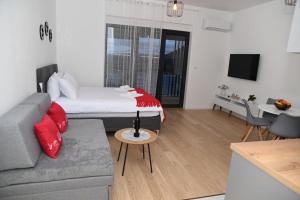 a living room with a bed and a couch at Apartman Perfect in Trebinje