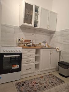 een keuken met witte kasten en een fornuis bij Paviljoni apartman in Tošin Bunar +7 foto's
