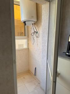 a shower with a glass door in a bathroom at Appartement à Skhirat plage in Skhirat