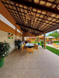 een patio met een tafel en stoelen onder een houten plafond bij Casa Beberibe in Beberibe