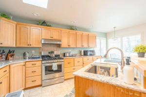 a kitchen with wooden cabinets and stainless steel appliances at Charming beach home with Ocean & Mt. Baker View in Camano