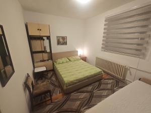 a small bedroom with a bed and a chair at Prenoćište Dika in Višegrad