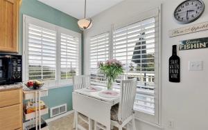 a kitchen with a white table and chairs and a clock at Charming beach home with Ocean & Mt. Baker View in Camano