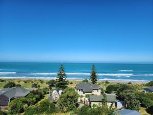 an aerial view of a house and the ocean at Gore Bay View, Tiny Pod, Treehouse in Gore Bay