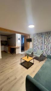 Una sala de estar con un sofá y sillas y una mesa. en Apartamenty Dąbrówka Cieplice Zdrój, en Jelenia Góra