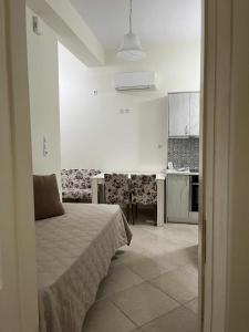 a white room with a bed and a kitchen at Kantouni house Chios in Pyrgi