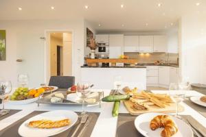 Una cocina con una mesa con comida y copas de vino. en have-a-nice-Stay - Penthouse I Innenstadt I wenige Minuten zum Bahnhof I riesige Dachterrasse, en Ahrensburg 36 fotos más