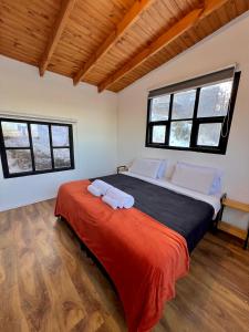 Casa Mirador Austral La familia entera en un solo lugar con una increíble vista y tranquilidad في أوشوايا: غرفة نوم بها سرير كبير وبطانية حمراء