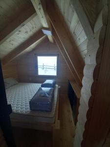 an attic room with two beds and a window at Planinska Vikendica SP Jahorina in Bistrica