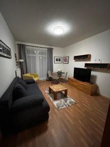 a living room with a black couch and a table at Apartmán Lucie Špindlerův Mlýn in Špindlerův Mlýn