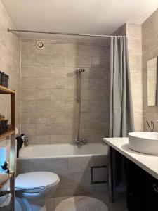 a bathroom with a tub and a toilet and a sink at Design studio met hotel vibe in Antwerp