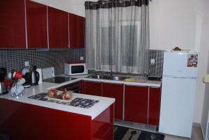 a kitchen with red cabinets and a white refrigerator at sofi in Komotini