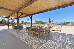 een patio met tafels en stoelen op het strand bij Maui Eldorado Condo G101 in Kaanapali