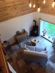 an overhead view of a living room with a couch and a wood stove at Le Grand Meix - La Petite Grange in Escles