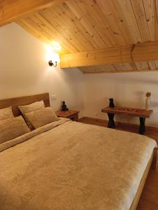 a bedroom with a large bed and a table at Le Grand Meix - La Petite Grange in Escles