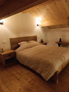 a bedroom with a bed and a wooden ceiling at Le Grand Meix - La Petite Grange in Escles
