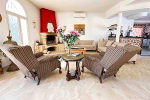 Dar RetbaにあるDar Kmar A sweet getaway in the hills of Hammametのリビングルーム(椅子2脚、花のテーブル付)