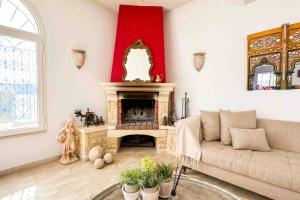 Dar RetbaにあるDar Kmar A sweet getaway in the hills of Hammametのソファと暖炉のあるリビングルーム +19枚の写真