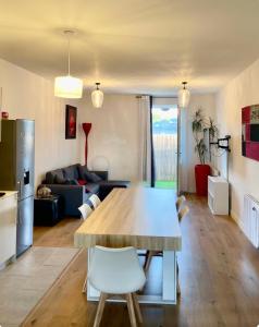 Maison accès plage 1 à 6 personnes - Saint Georges d Oleron - Boyardville - 2 chambres - animaux acceptés nid d été في سا جورج دوليه: مطبخ وغرفة معيشة مع طاولة خشبية كبيرة