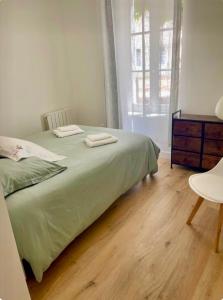 Maison accès plage 1 à 6 personnes - Saint Georges d Oleron - Boyardville - 2 chambres - animaux acceptés nid d été في سا جورج دوليه: غرفة نوم بها سرير عليه منشفتان