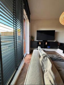 a living room with a couch and a flat screen tv at BOHO Oasis Radom - Dom z parkingiem in Radom