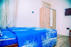 Aubri Homes في آكرا: سرير أزرق في غرفة مع مرآة