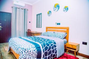 Aubri Homes في آكرا: غرفة نوم بسرير من اللون الازرق والابيض