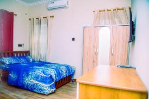 Aubri Homes في آكرا: غرفة نوم بسرير وطاولة خشبية