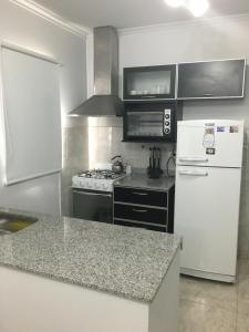 a kitchen with a stove and a white refrigerator at Apartamento Los Abuelos Calle Peron in Colón