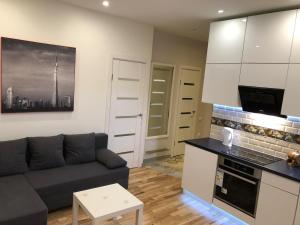 a living room with a couch and a kitchen at B-happy Apartments in Vilnius