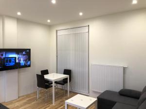a living room with a table and a tv on a wall at B-happy Apartments in Vilnius