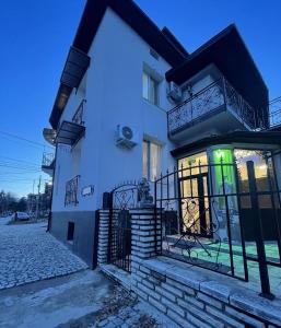 a white house with a green light in the window at Къща за гости Деметра in Velingrad