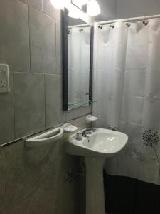 a bathroom with a sink and a shower with a mirror at Apartamento Los Abuelos Calle Peron in Colón