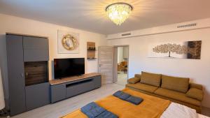 a living room with a couch and a flat screen tv at CasaBruno Vendégház Celldömölk in Celldömölk