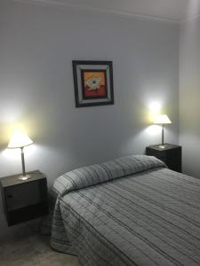 a bedroom with a bed and two tables with lamps at Apartamento Los Abuelos Calle Peron in Colón