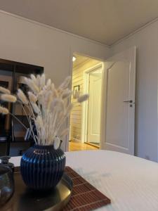 a vase with white flowers sitting on a table at Cozy Central Apartment - Free Parking & Wifi in Vossevangen +15 photos