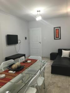 a living room with a table and a black couch at Apartamento Los Abuelos Calle Peron in Colón