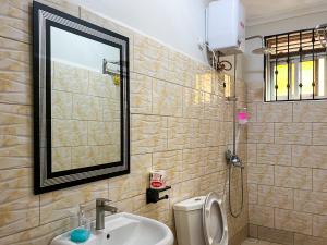a bathroom with a sink and a mirror and a toilet at Keisha Luxury Furnished Apartment Bukoto in Kampala +139 photos