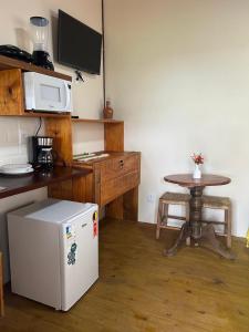 a small kitchen with a table and a microwave at Suíte da Alê in Marau +3 photos