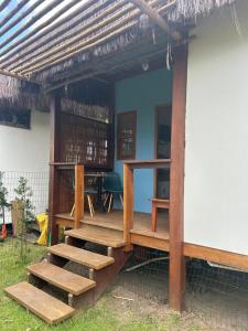 a porch of a house with wooden steps at Suíte da Alê in Marau