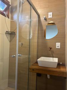 a bathroom with a sink and a glass shower at Suíte da Alê in Marau