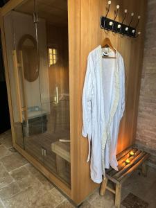 un peignoir accroché à un mur en bois à côté d'une douche dans l'établissement Gîte La Capucine, à Saint-Avertin