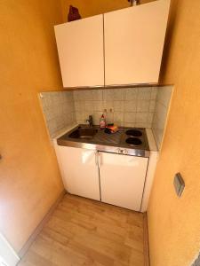 Fewo Warnemünde في روستوك: مطبخ صغير مع حوض ومكتب