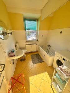 Fewo Warnemünde في روستوك: حمام مع مغسلة وحوض استحمام